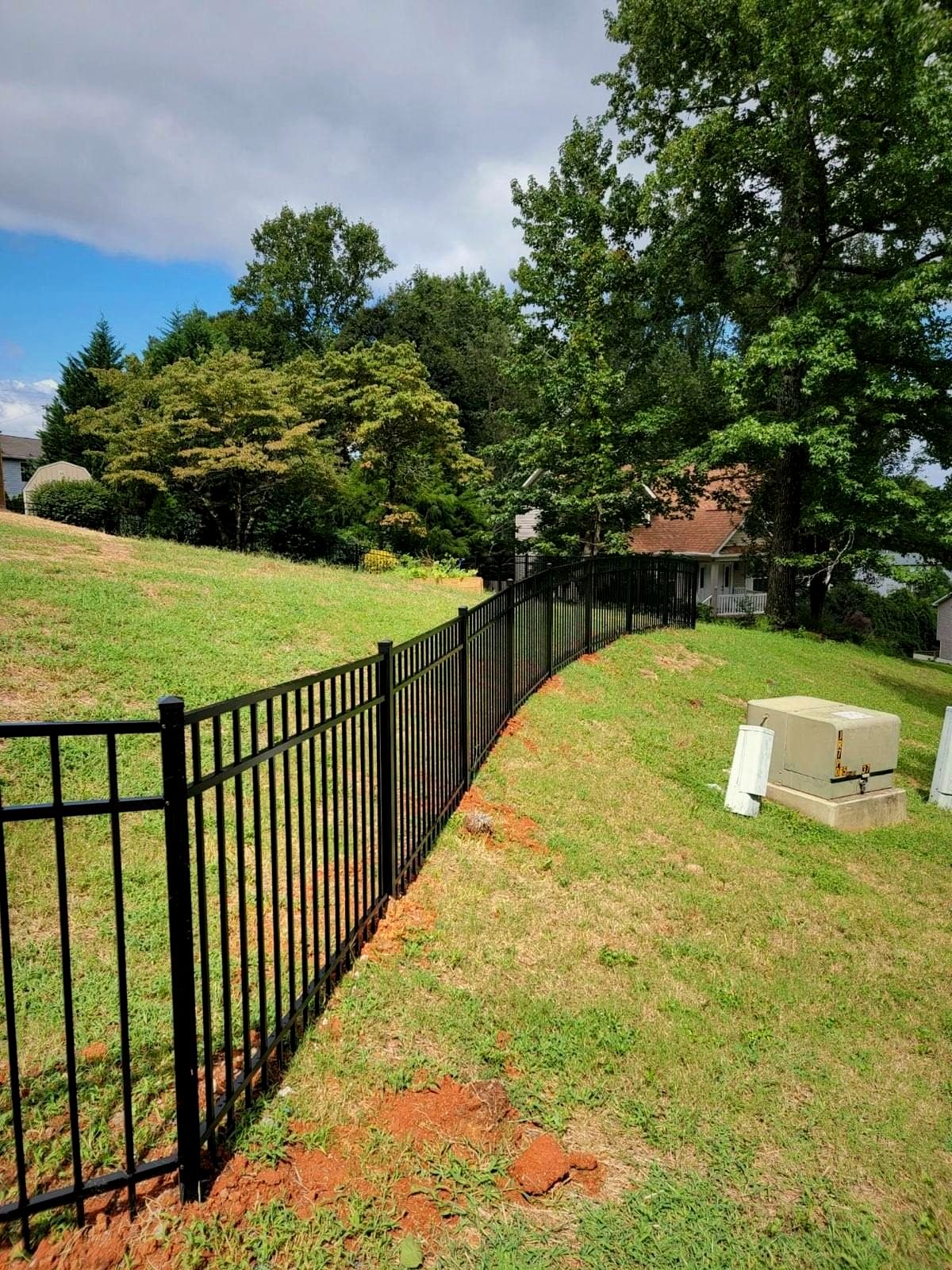 Black aluminum fence following a hillside