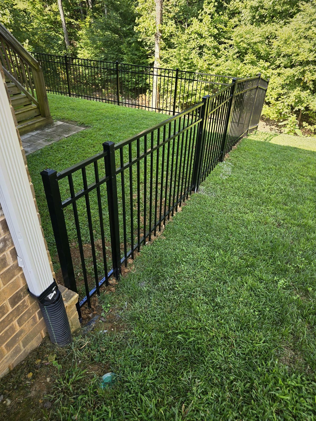 Black aluminum fence along a lawn