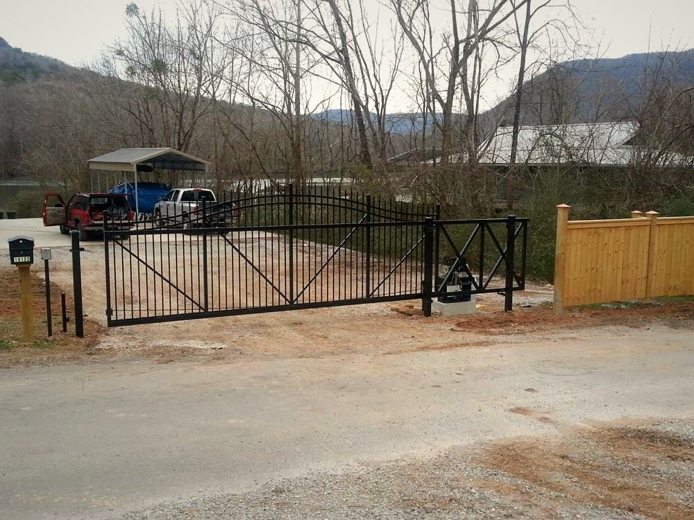 Black aluminum driveway gate with the mountains behind it