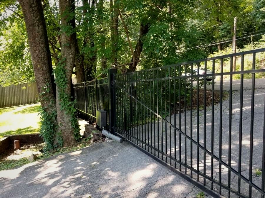 Automatic aluminum swing gate on a wooded driveway