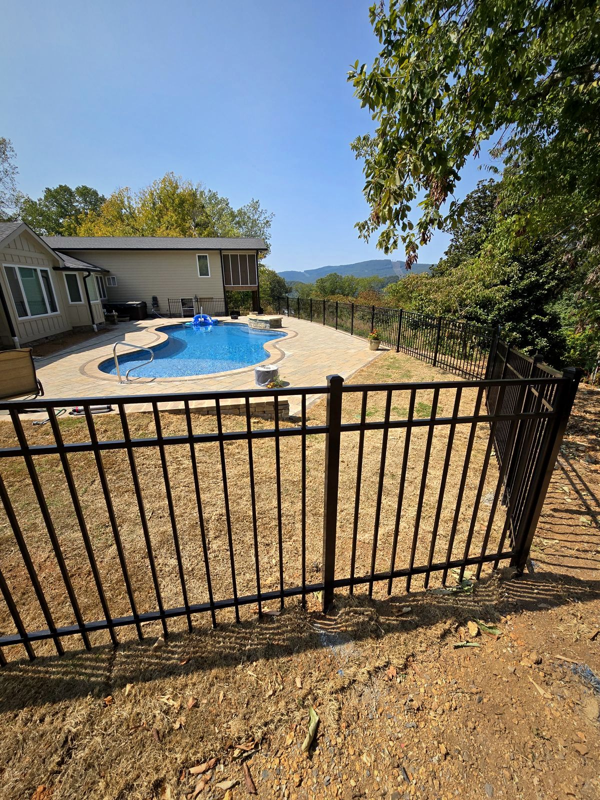 Black aluminum fence around a backyard pool with a mountain view