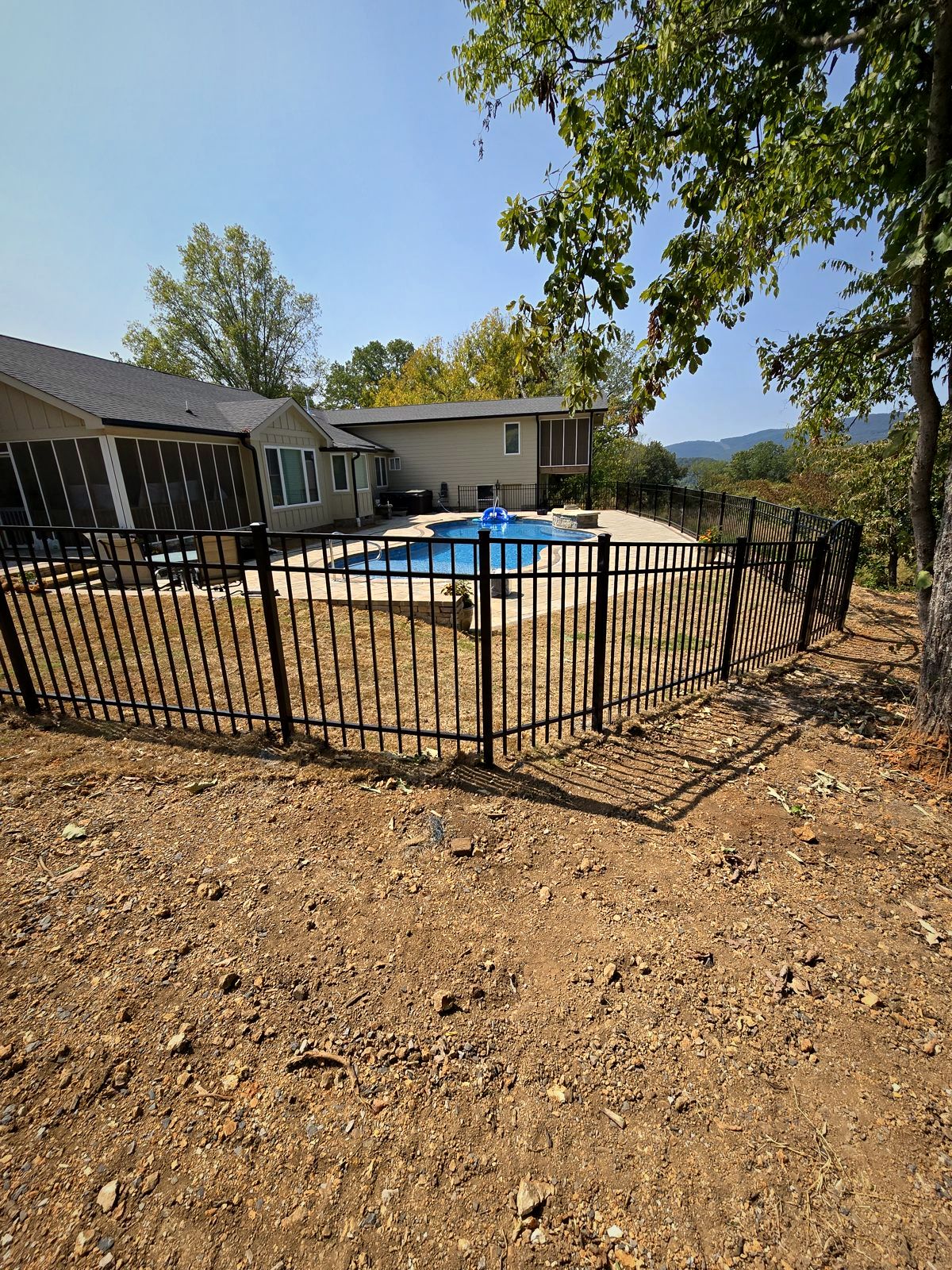 New black aluminum pool fence around an in-ground pool