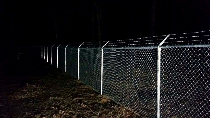 Chain link fence topped with barbed wire