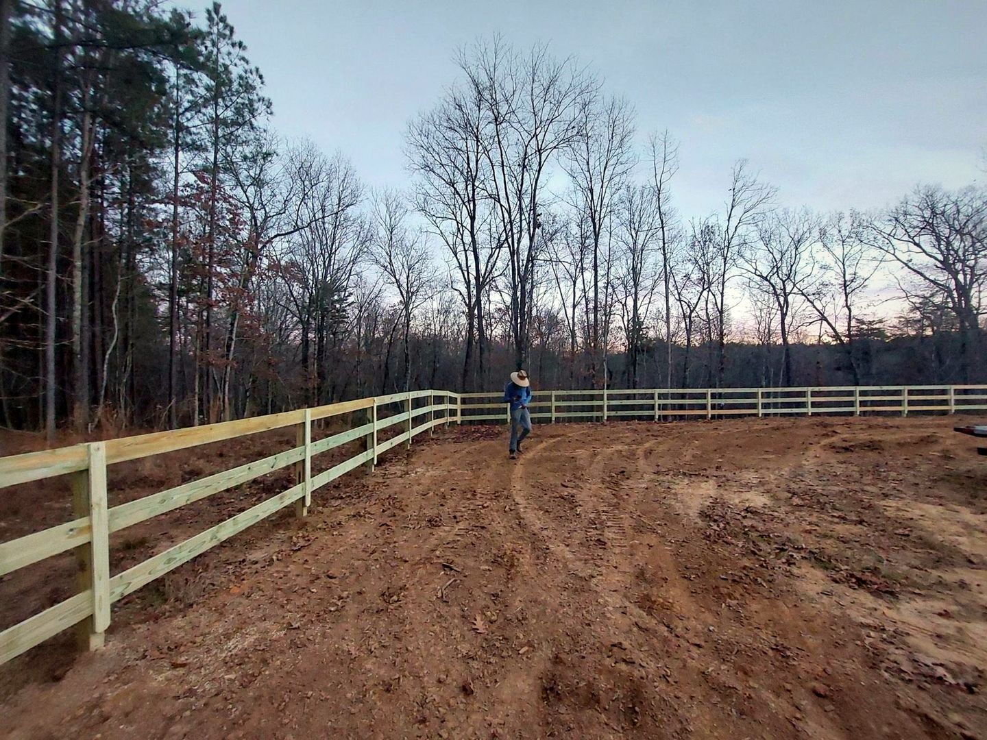 Three-rail wood fence along a pasture