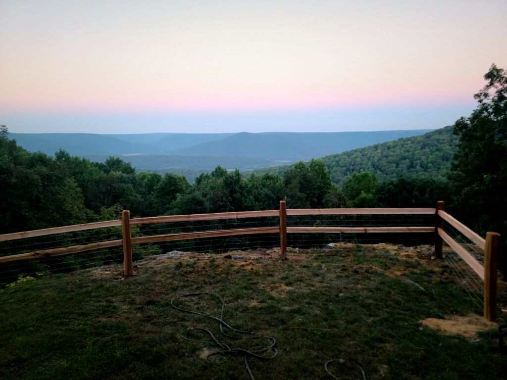 Split-rail wood fence on a ridge overlooking the mountains at dusk