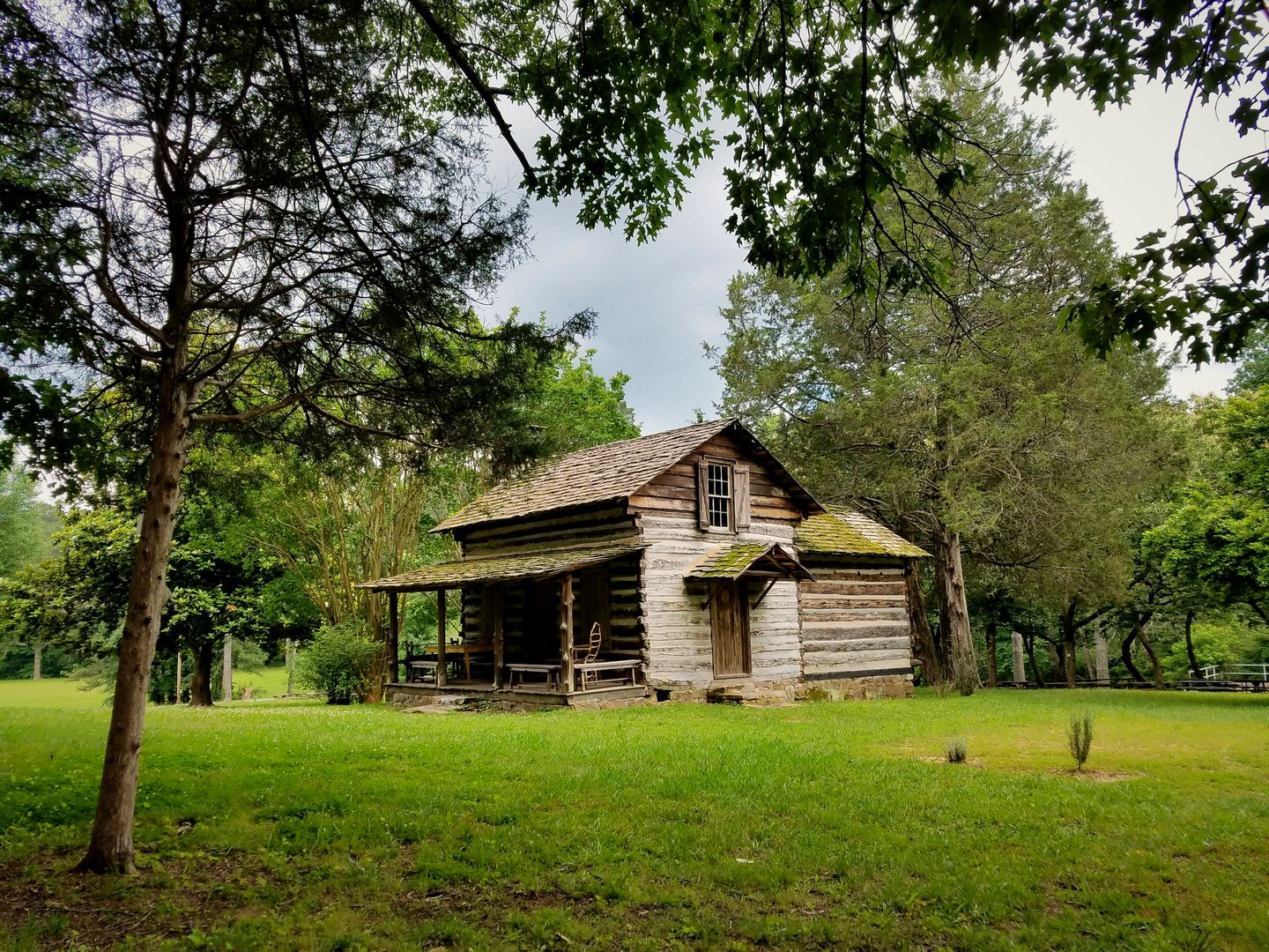 The historic Spring Frog Cabin among the trees at Audubon Acres in East Brainerd