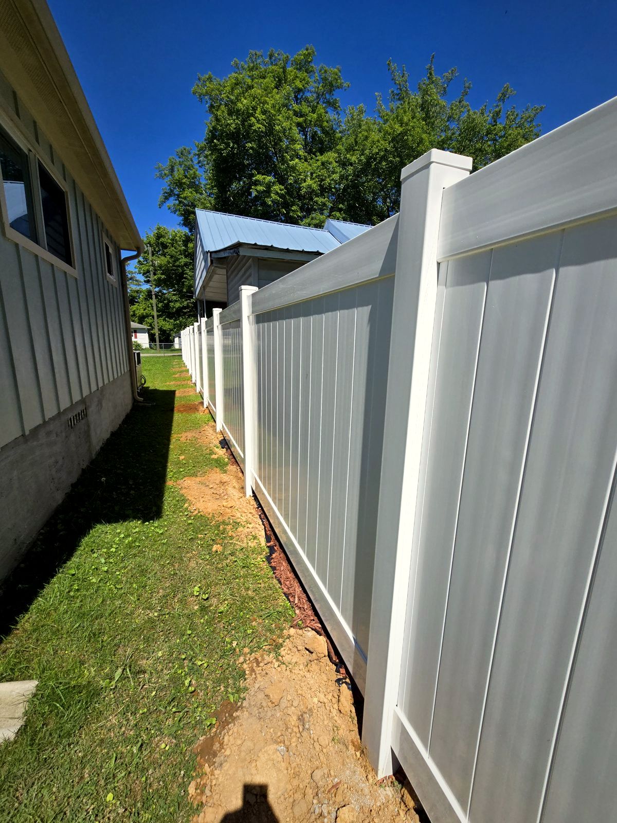 White vinyl privacy fence beside a home