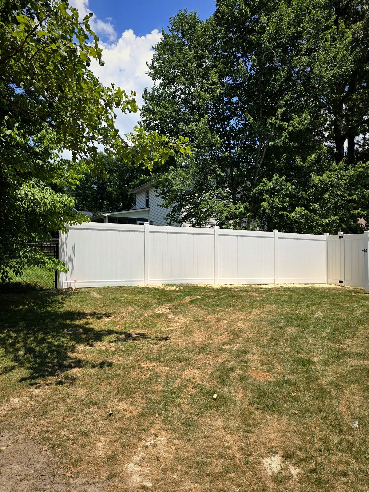 White vinyl privacy fence across a backyard