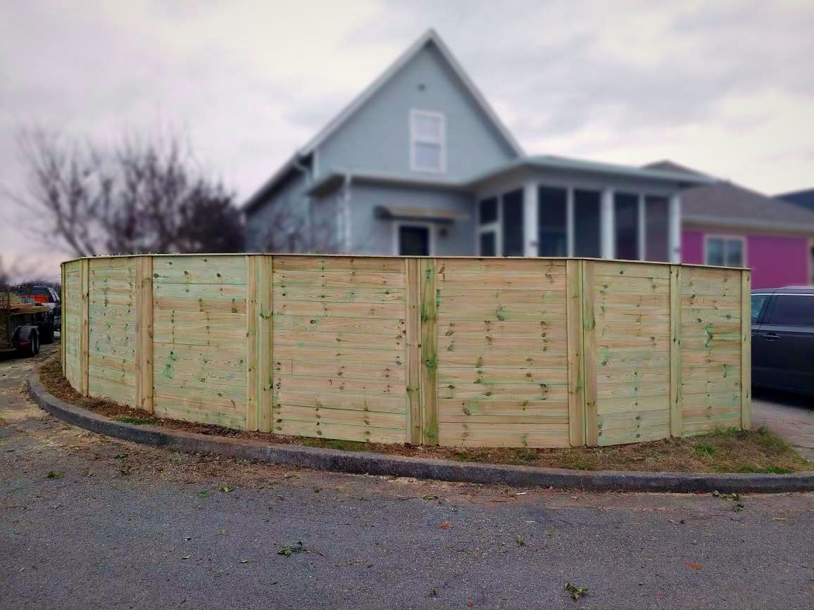Horizontal wood privacy fence curving along a street
