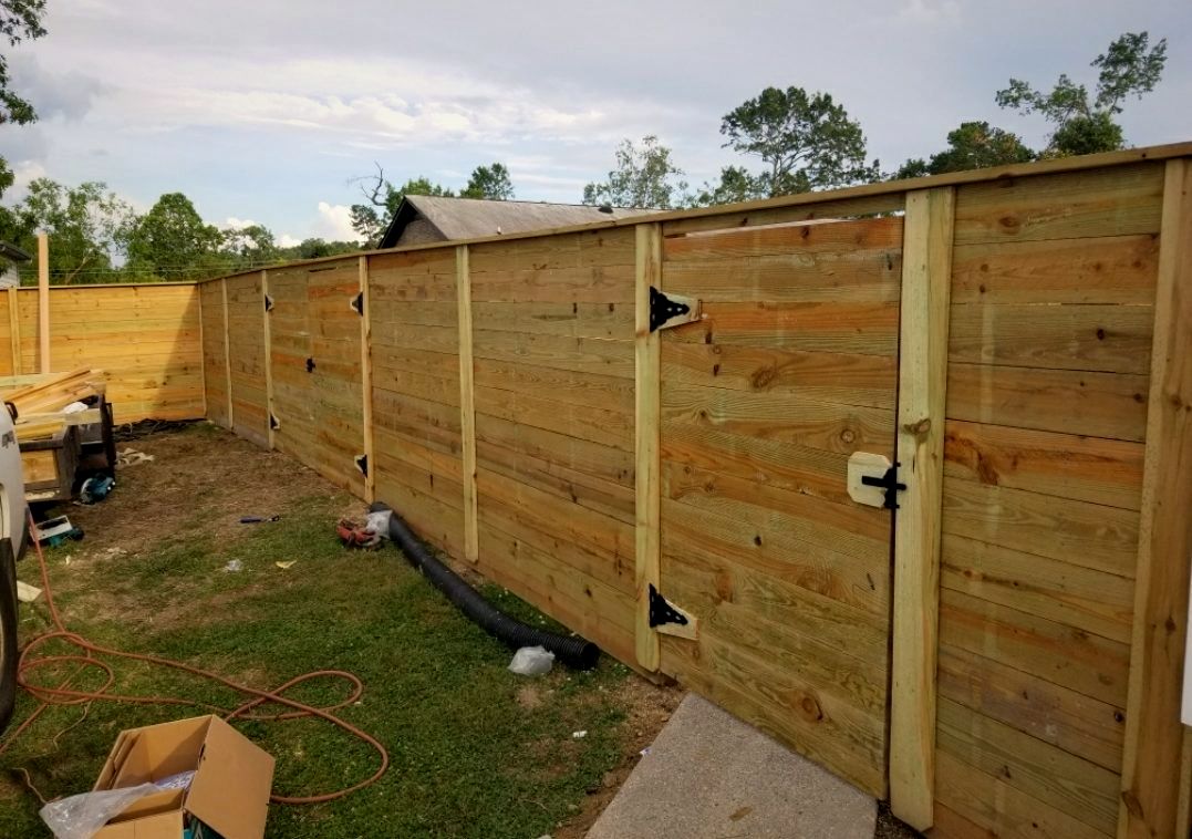 Horizontal wood privacy fence with a walk gate