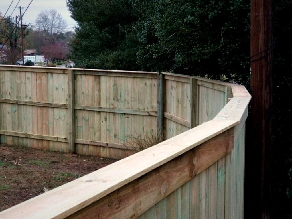 Capped wood privacy fence following a curve