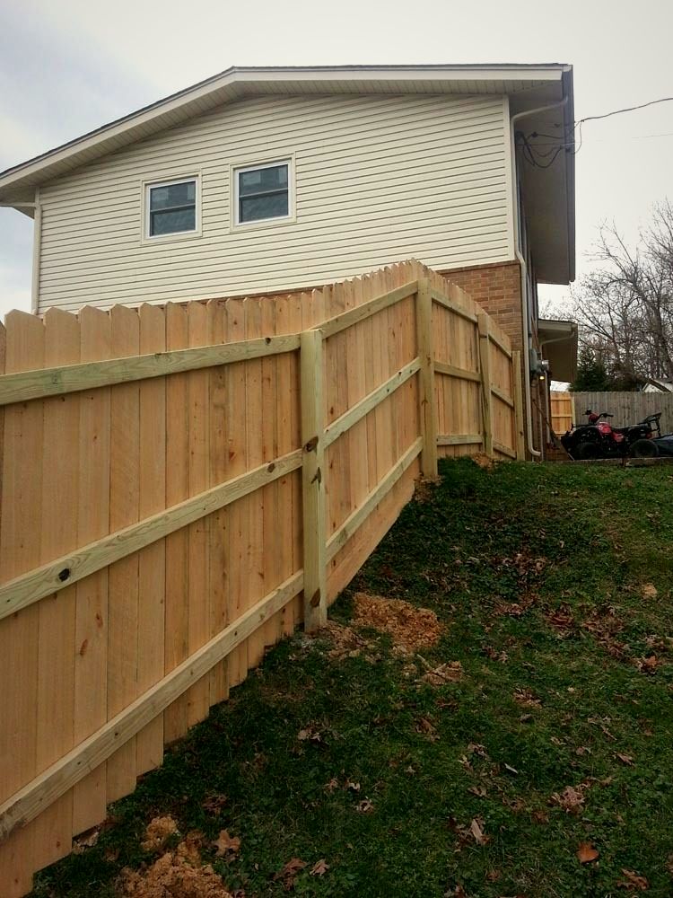 Wood privacy fence running along the side of a two-story home