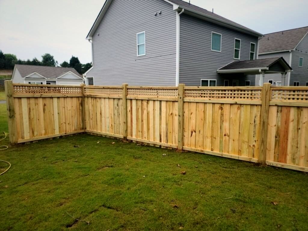 Wood privacy fence with a lattice top behind a new home