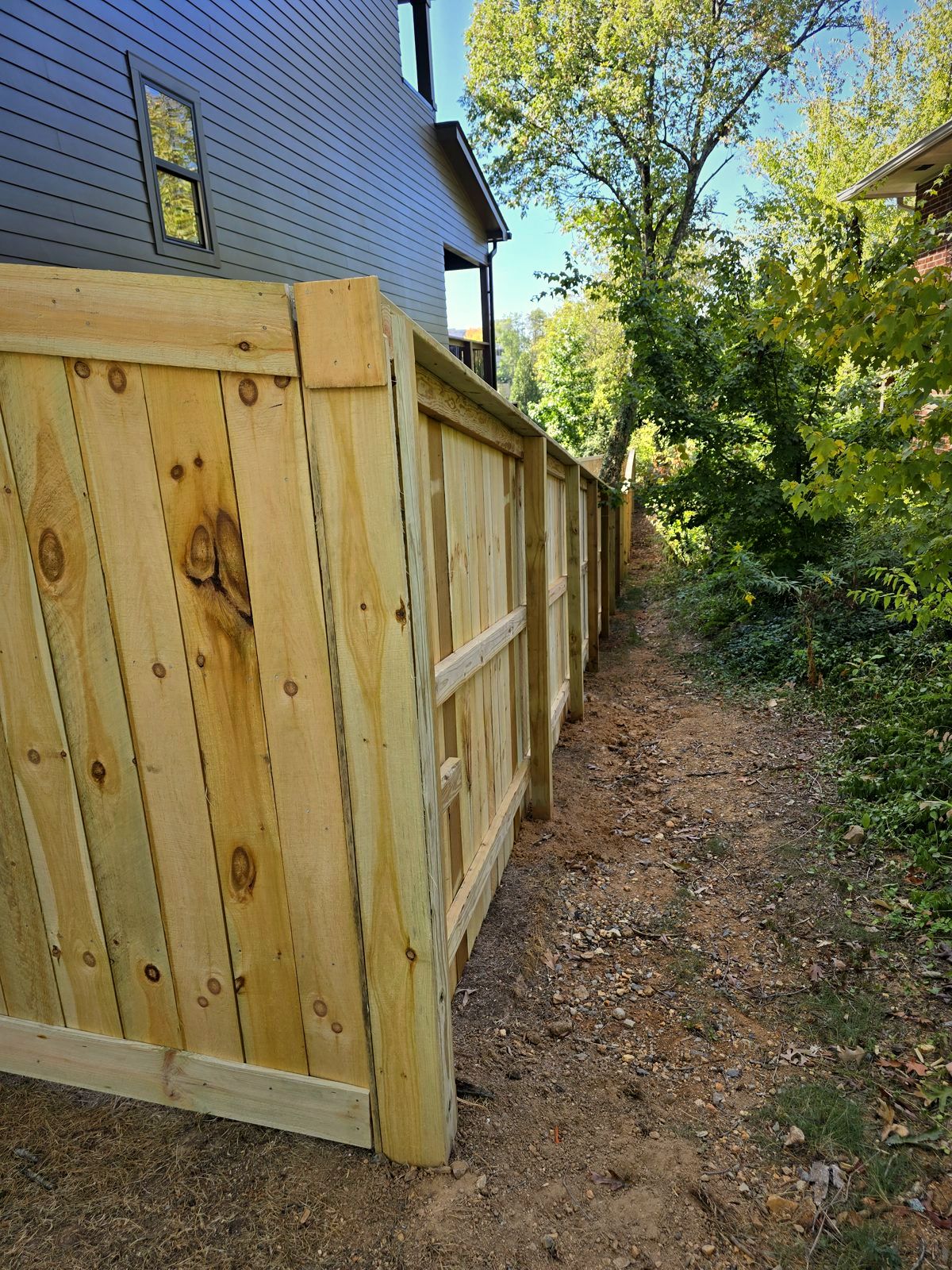 Wood board privacy fence running down a narrow side yard