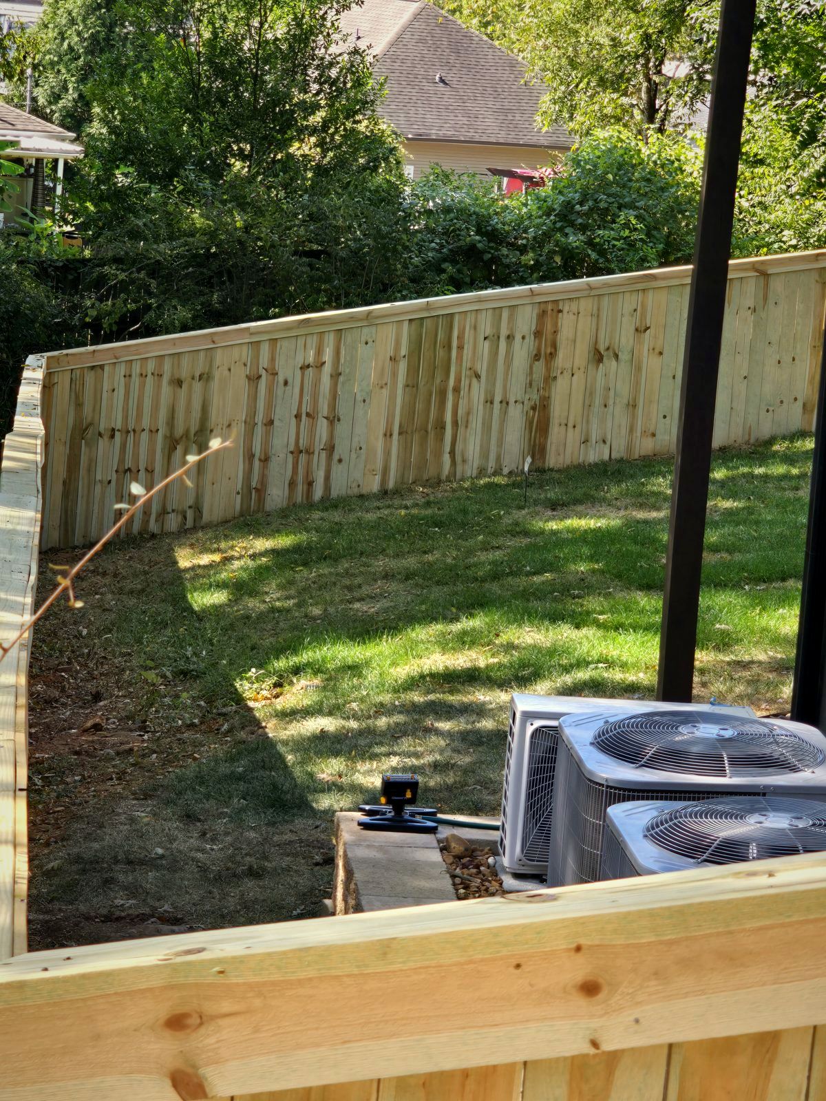 Wood privacy fence around a sloped backyard