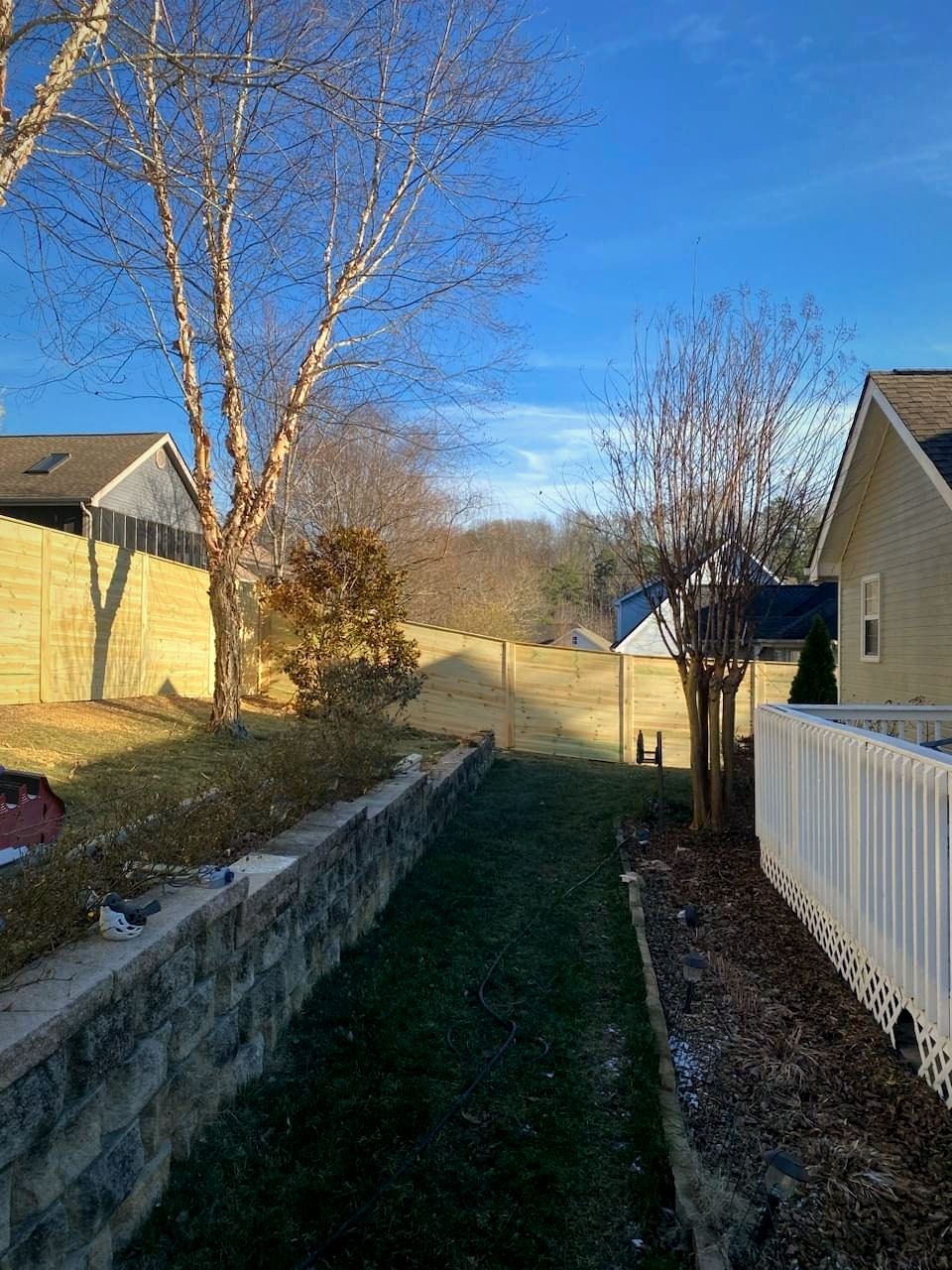 Wood privacy fence above a block retaining wall