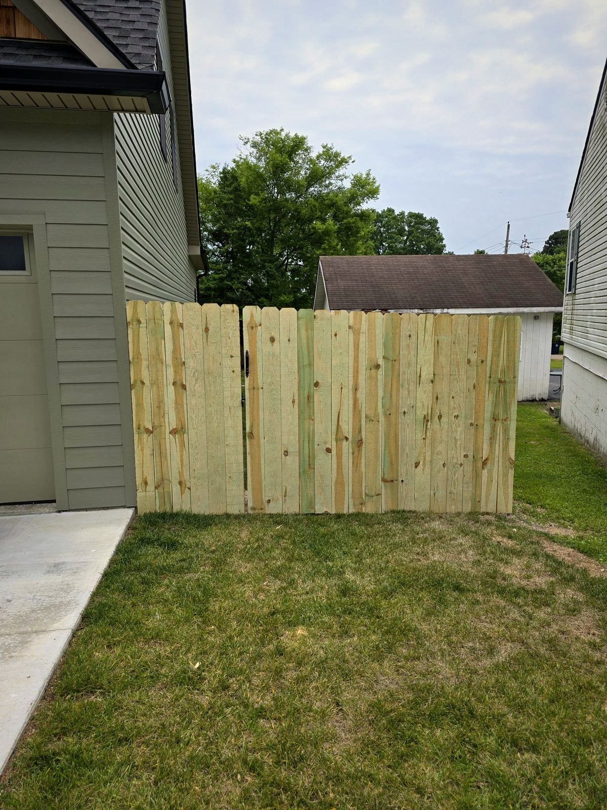 Wood privacy fence and walk gate closing off a side yard