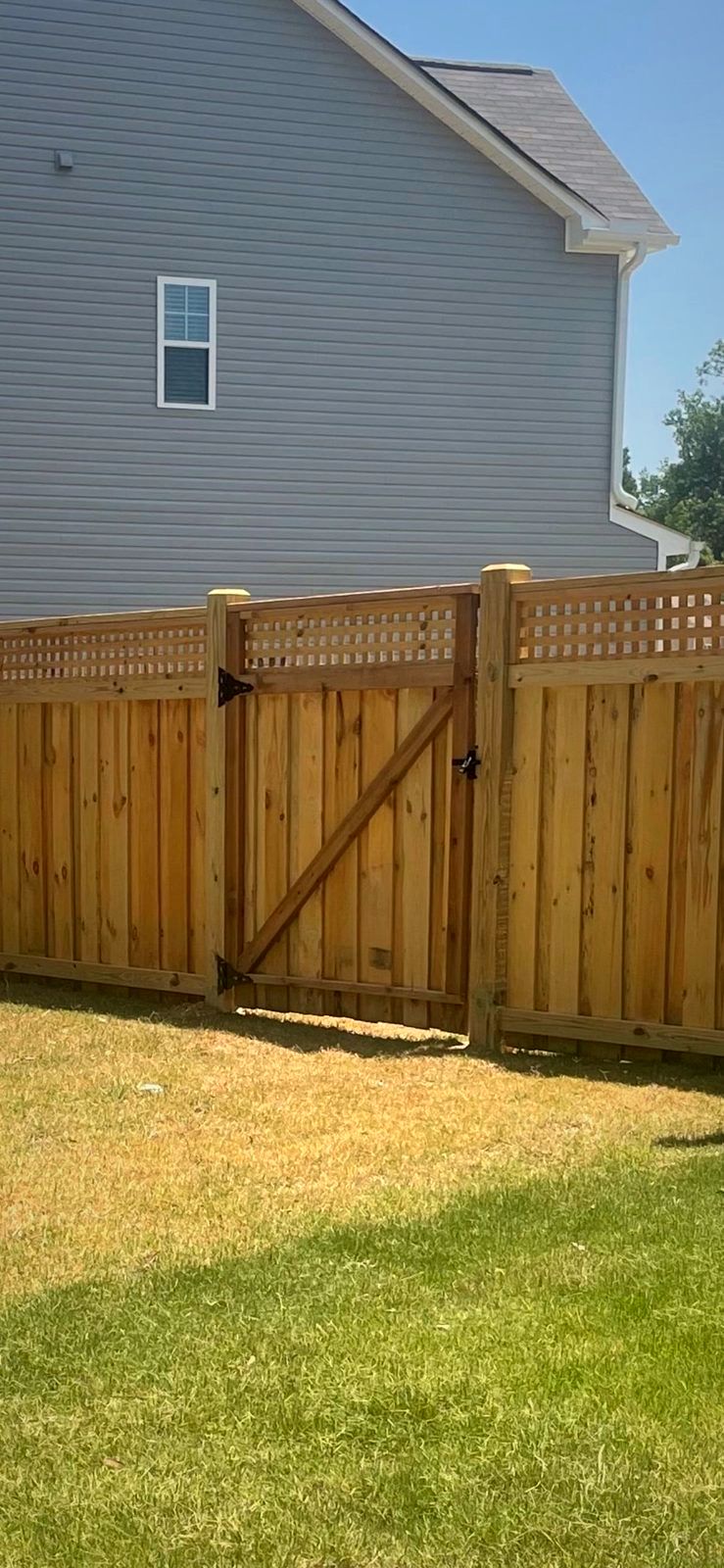 Wood privacy fence with a lattice top and gate